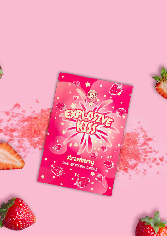 Pink packaging of 'Explosive Kiss' strawberry candy on a pink background with strawberries.
